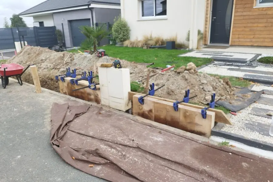 Assemblage des madriers du muret en bois, serrage et mise à niveau