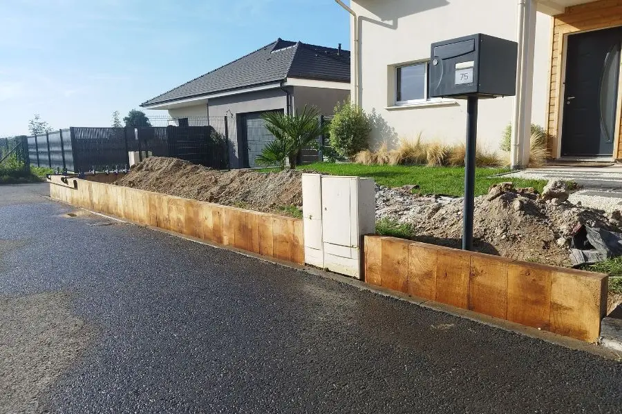 Muret de soutènement en bois sur toute la longueur de la façade